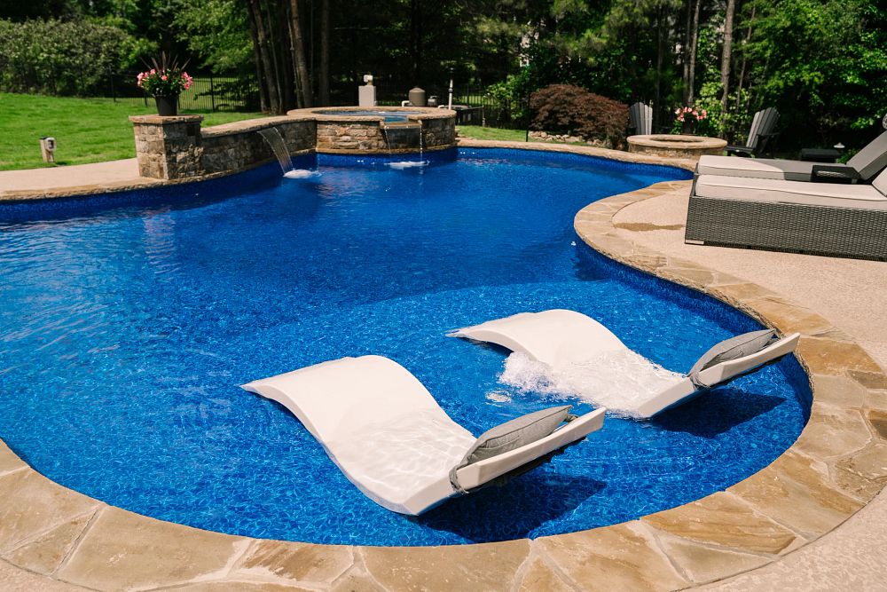inground swimming pool with tanning ledge and spa