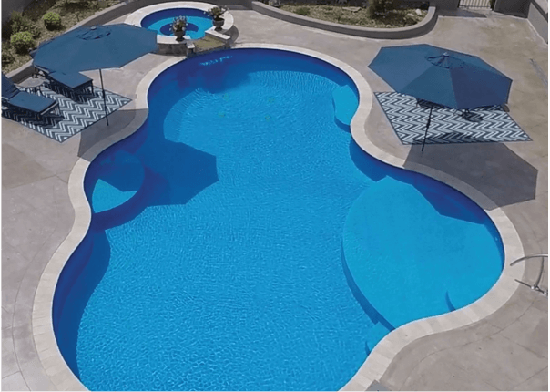 inground swimming pool with tanning ledge and spa