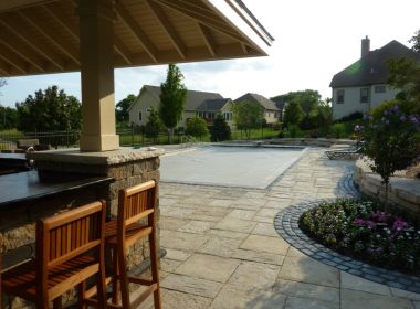 inground pool behind outdoor kitchen