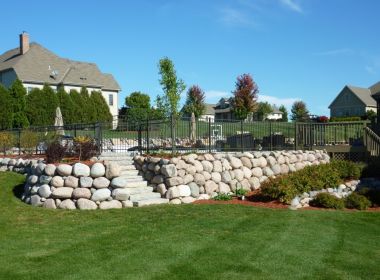 inground pool with stone boulder retaining wall